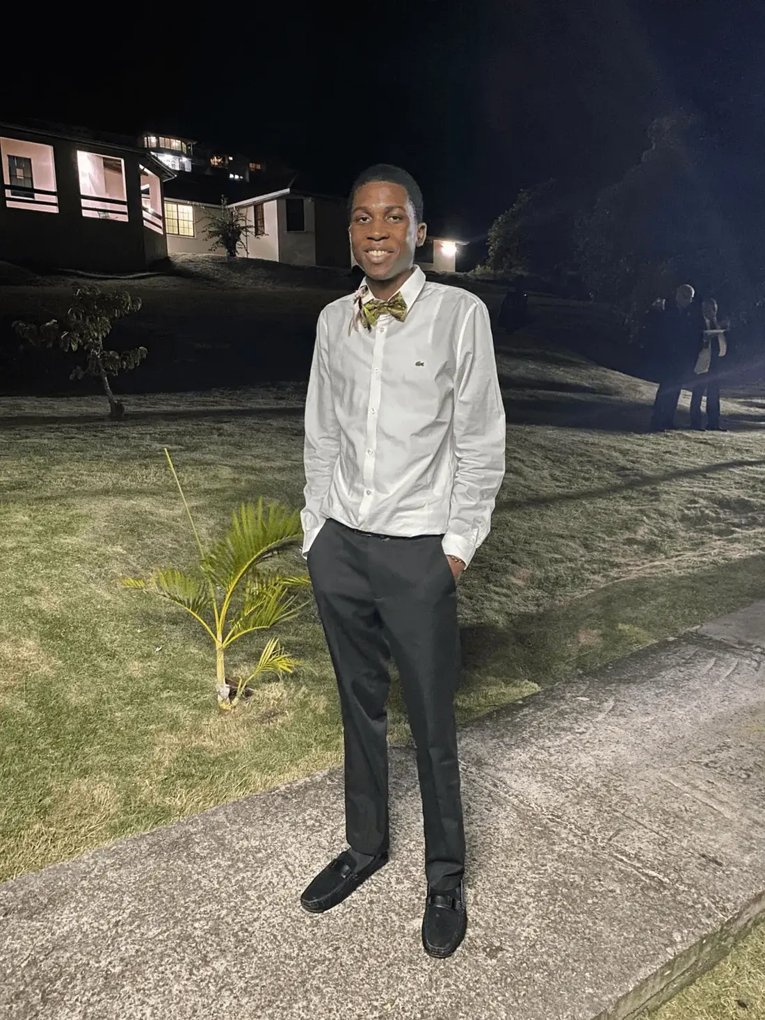 Cheyne Cazaubon, founder of CJN Digital Solutions, smiling outdoors in the evening wearing a white button-down shirt and patterned bow tie