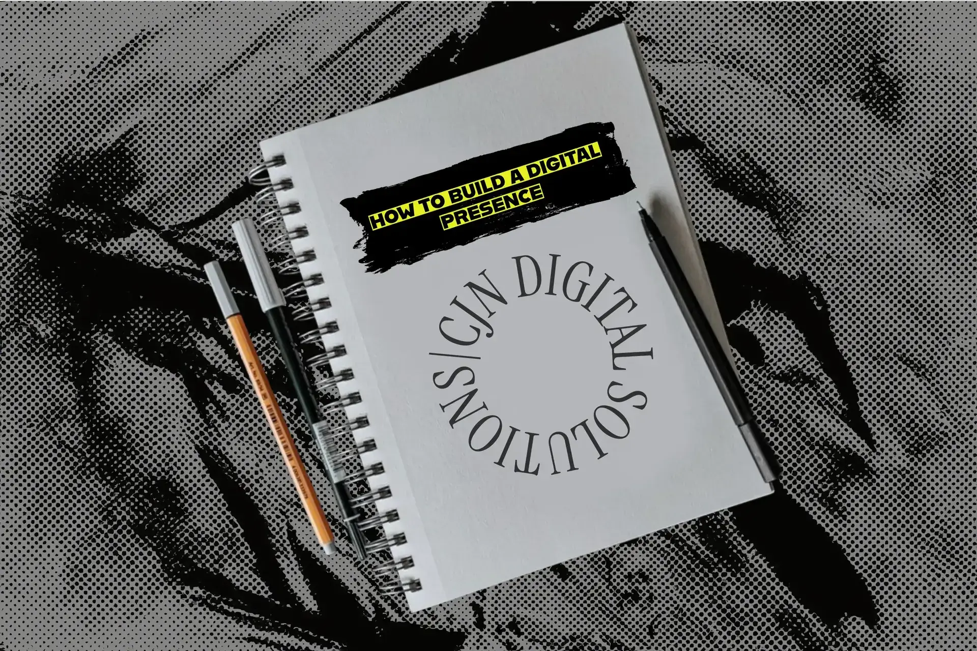 Spiral notebook with 'How to Build a Digital Presence' with web design headline and CJN Digital Solutions logo, styled with a black and yellow highlighter design and a high-contrast halftone background, flanked by a pen and pencil